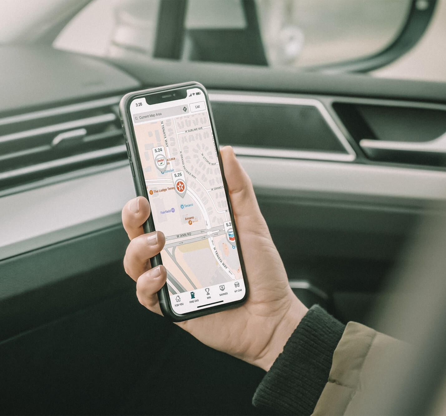 A person using GasBuddy in a car